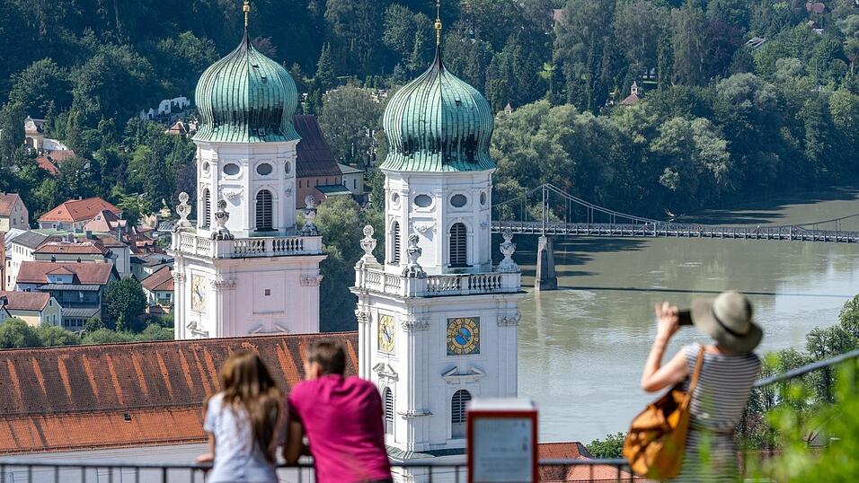 Touristen stehen bei sommerlichen Temperaturen vor dem Dom St. Stephan. (Archivbild)