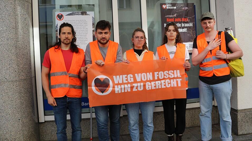 Die Protestler vor einer der beklebten Banken.