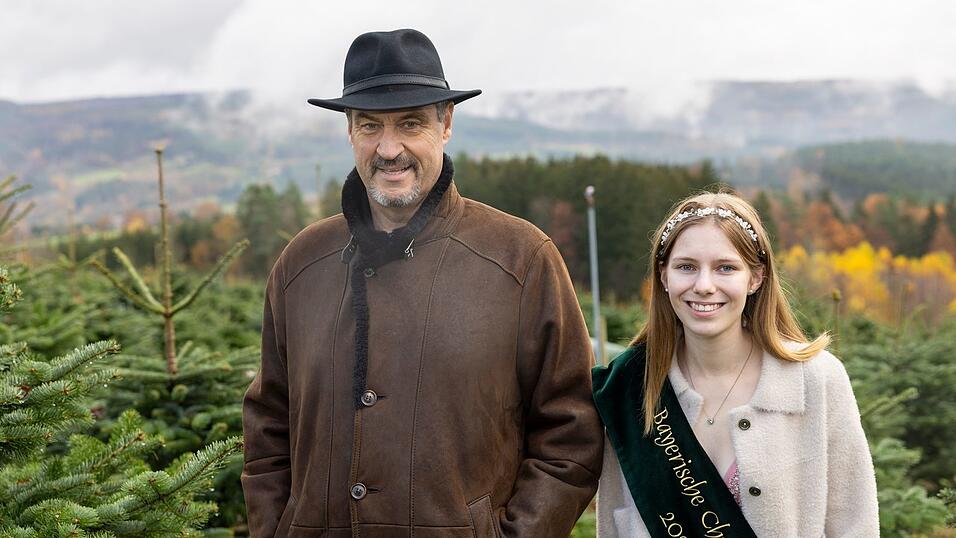 Ministerpräsident Markus Söder (CSU, l) schaute mit Christbaumkönigin Sina Klug im Christbaumdorf im unterfränkischen Mittelsinn vorbei.