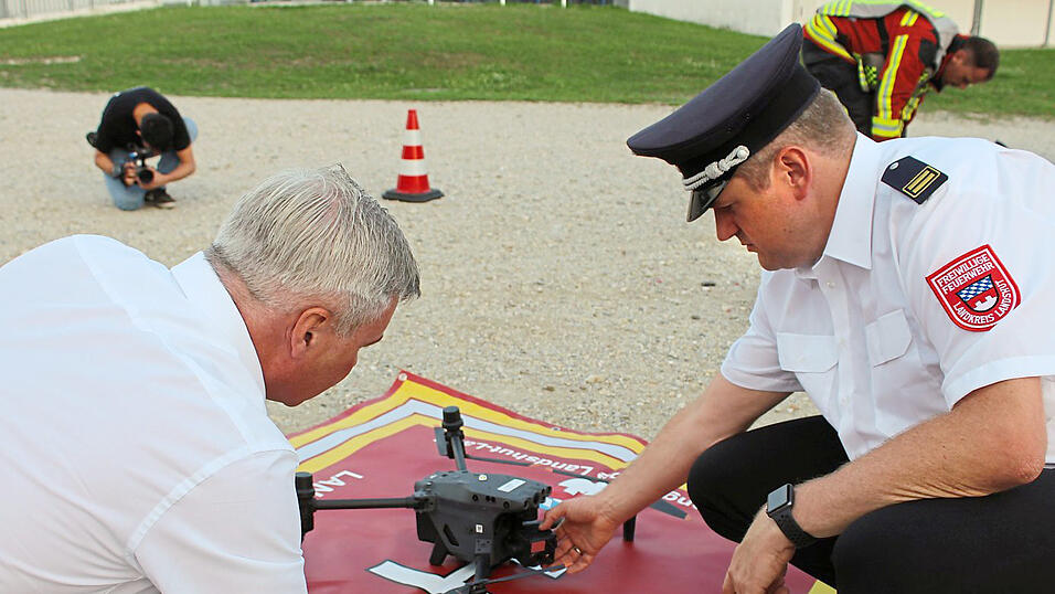 Fach-Kreisbrandmeister Information und Kommunikation J&uuml;rgen Unfall (r.) erkl&auml;rt Landrat Peter Dreier, wo die Kameras an der Drohne angebracht sind.