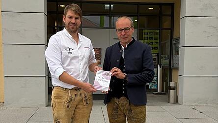 Vorsitzender Florian Wimberger und B&uuml;rgermeister Martin Hiergeist mit der frisch gedruckten 100-seitigen Jubil&auml;umschronik.
