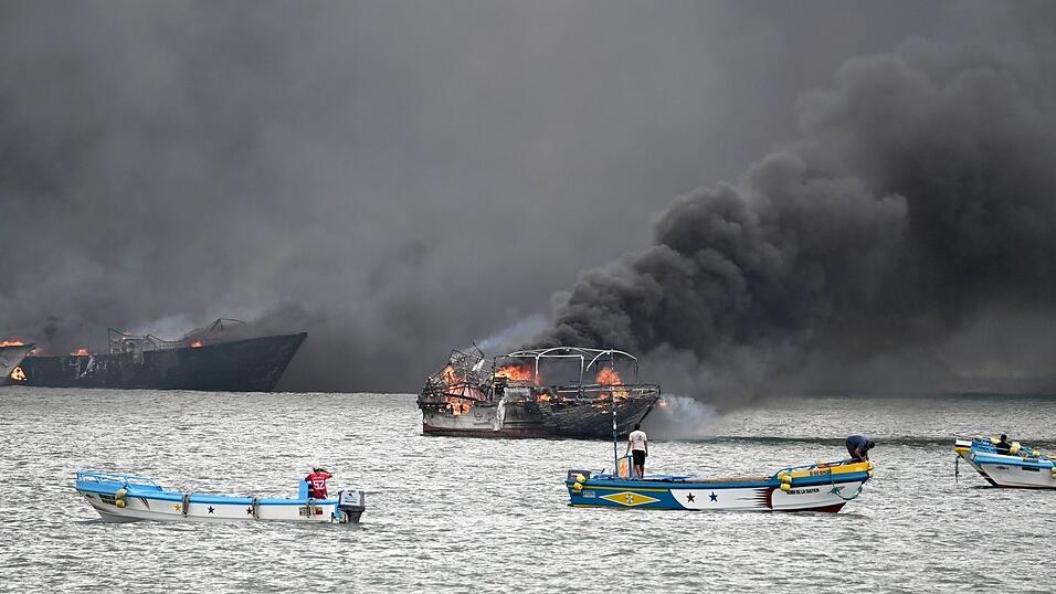 Im Hafen von Manta stehen mehrere Fischerboote in Flammen. Im Hafen von Manta stehen mehrere Fischerboote in Flammen.