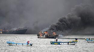 Im Hafen von Manta stehen mehrere Fischerboote in Flammen. Im Hafen von Manta stehen mehrere Fischerboote in Flammen.