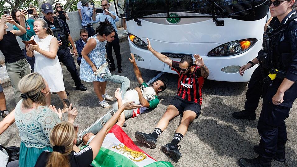 Demonstranten protestierten, w&auml;hrend der Bus mit iranischen Spielerinnen und Mitarbeitern abfuhr.