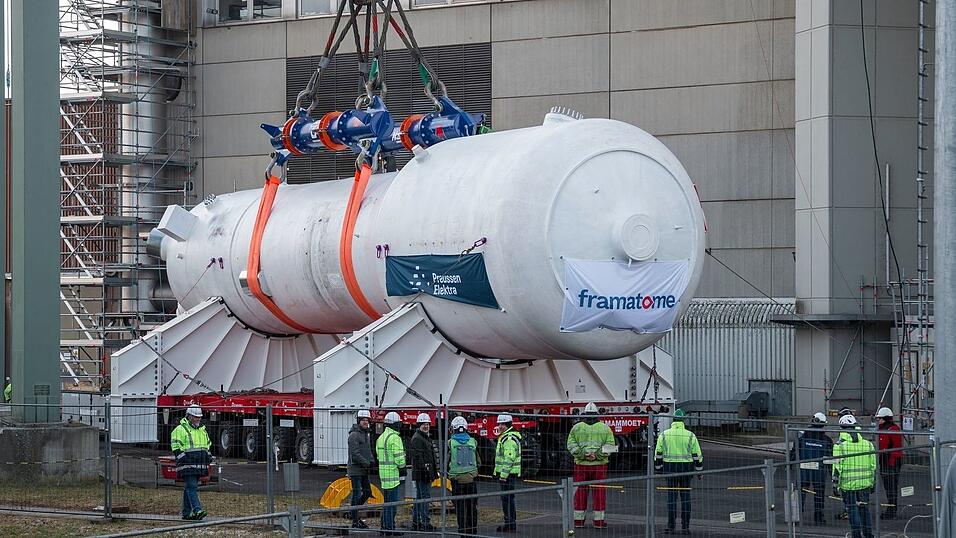 Ein Dampferzeuger wird mithilfe eines Schwerlastkrans aus dem Reaktorgeb&auml;ude gehoben und auf zwei Tr&auml;ger f&uuml;r den Weitertransport montiert.