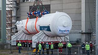 Ein Dampferzeuger wird mithilfe eines Schwerlastkrans aus dem Reaktorgeb&auml;ude gehoben und auf zwei Tr&auml;ger f&uuml;r den Weitertransport montiert.