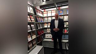 Vertriebs- und Marketingleiter Rainer Boos vor dem Messestand des Regensburger Verlags Schnell & Steiner.