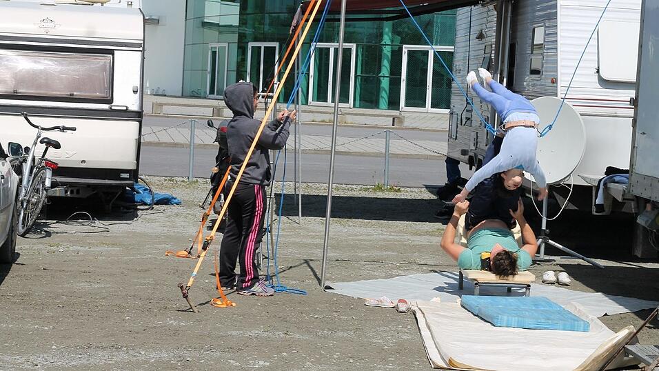 Hinter dem Zirkuszelt übt ein Nachwuchsartist Überschläge. Hinter dem Zirkuszelt übt ein Nachwuchsartist Überschläge.