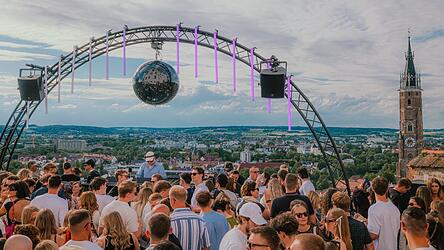 Unter einer schwarzen, einen Meter gro&szlig;en Discokugel feiern die G&auml;ste das &bdquo;Tanz die Trausnitz&ldquo;-Jubil&auml;um. Veranstalter J&uuml;rgen Gr&uuml;nbauer hat sie extra gekauft: &bdquo;Als Kind der Achtziger wei&szlig; ich: Keine Disco ohne Discokugel.&ldquo;
