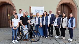 Die beiden Organisatorinnen Anja Spies und Andrea Stadler (Siebte und Achte von links), Oberb&uuml;rgermeister Alexander Putz, Sportbeauftragte Sabrina H&ouml;gl (rechts), Sponsoren und Unterst&uuml;tzer stellten bei einer Pressekonferenz das Programm des zehnten Firmenlaufs vor.