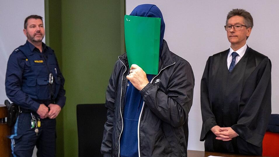 Der Angeklagte versteckte sich zu Prozessbeginn hinter einem grünen Karton - und räumte die Tat ein (Archivbild).