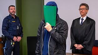 Der Angeklagte versteckte sich zu Prozessbeginn hinter einem grünen Karton - und räumte die Tat ein (Archivbild).