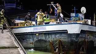 Einsatzkr&auml;fte brachten vorsorglich eine &Ouml;lsperre an dem havarierten Schiff an.