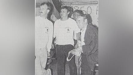 Karsten Wettberg im Juni 1991 nach dem Prominentenspiel im Festzelt. Zu sehen ist er hier mit Vertretern des 1860-Fanclubs Wiesent, die ihm einen Wimpel samt Bierkrug schenkten - und einen Regenschirm, nachdem er seinen eigenen beim Aufstieg zertr&uuml;mmert hatte.