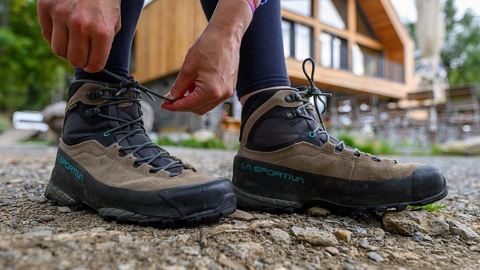 Eine Frau schn&uuml;rt ihre Wanderschuhe. Deutschland gilt mit seinen vielf&auml;ltigen Landschaften und Regionen als Wanderland.