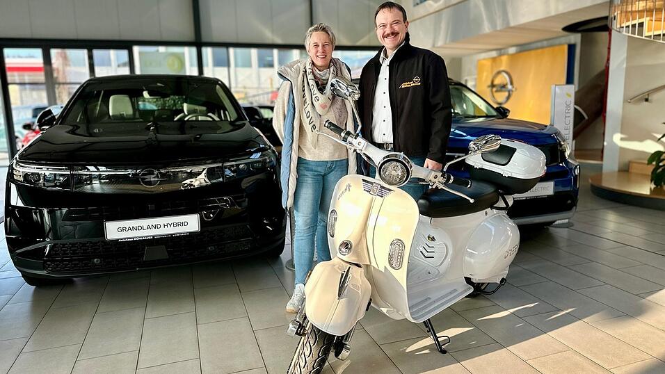 Christkindlmarkt-Organisatorin Stephanie Schächtl und Autohaus-Chef Siegi Mühlbauer präsentieren den E-Roller, den es beim Christkindlmarkt am ersten Advent-Wochenende zu gewinnen gibt.