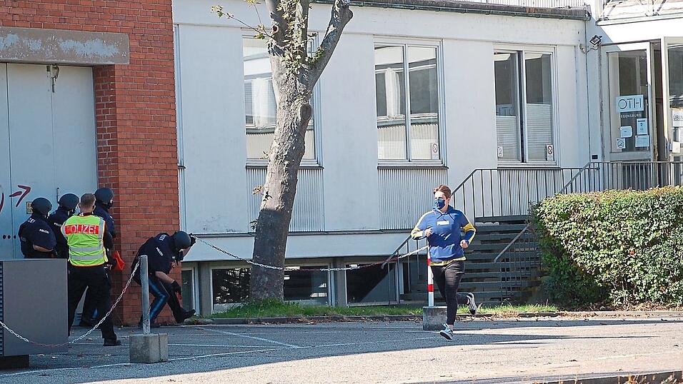 Die Beamten nähern sich der Tür des OTH-Gebäudes. Derweil flüchtet ein 'Opfer', gespielt von einem Praktikanten, aus dem Haus. Die Beamten nähern sich der Tür des OTH-Gebäudes. Derweil flüchtet ein 'Opfer', gespielt von einem Praktikanten, aus dem Haus.