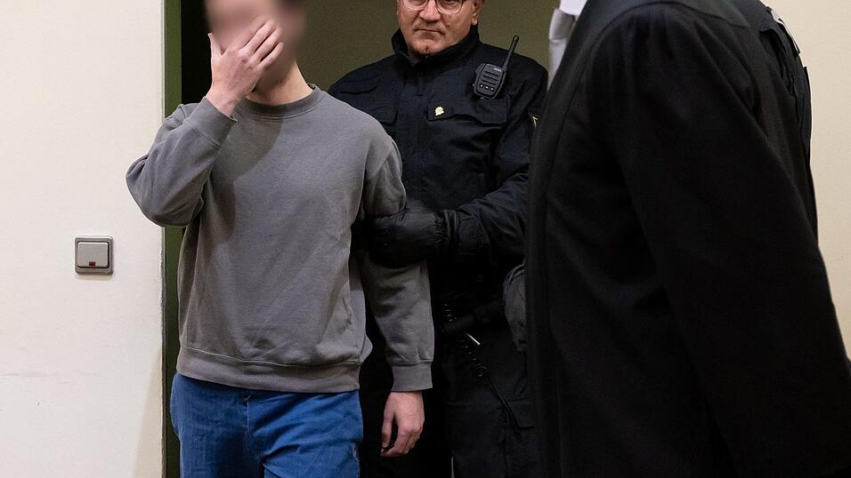 Der Angeklagte wird in den Verhandlungssaal geführt. Laut Anklage hatte der Mann 2021 in dem Fernzug Passau-Hamburg vier Männer angegriffen und mit einem Messer zum Teil schwer verletzt. Der Angeklagte wird in den Verhandlungssaal geführt. Laut Anklage hatte der Mann 2021 in dem Fernzug Passau-Hamburg vier Männer angegriffen und mit einem Messer zum Teil schwer verletzt.