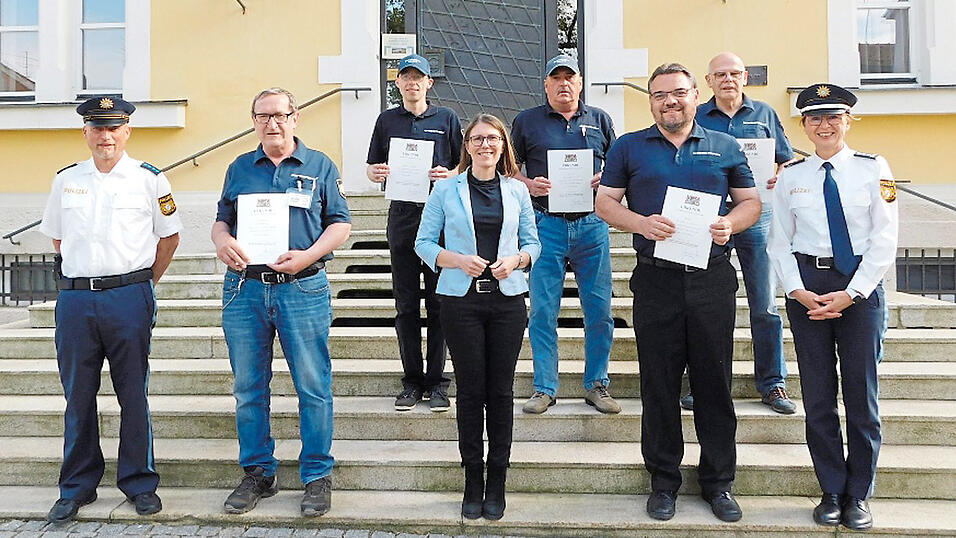 B&uuml;rgermeisterin Andrea Probst (Mitte) mit f&uuml;nf der geehrten Sicherheitswacht-Jubilare, Polizeihauptmeister Roland Kappelmann (links) und 1. Polizeihauptkommissarin Daniela Neumayer (rechts).