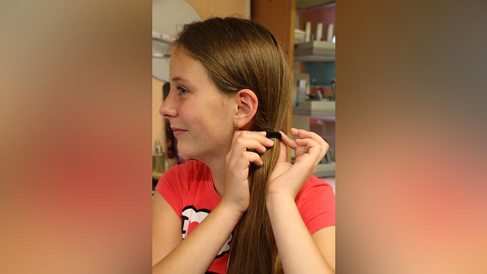 2. Dann flicht sie einen Fischgr&auml;tzopf: Dazu teilt sie ihren Zopf in zwei Partien. Von der rechten Partie nimmt sie von hinten eine d&uuml;nne Str&auml;hne auf, legt sie &uuml;ber die rechte Partie auf die andere Seite und l&auml;sst sie dort h&auml;ngen. Dann nimmt sie eine Str&auml;hne von der linken Seite und legt sie &uuml;ber diesen Strang zur rechten Partie. Auf diese Art f&auml;hrt sie fort, bis sie bei den Haarspitzen angelangt ist. Dazwischen zieht sie den Zopf immer wieder fest. Das Ganze braucht ein bisschen &Uuml;bung. Am besten zuerst einmal bei einer Freundin ausprobieren. Es gilt: Je d&uuml;nner die Str&auml;hnen, umso sch&ouml;ner!