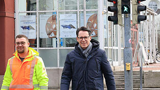 Stadt-Mitarbeiter Florian Geiger und Oberb&uuml;rgermeister Dr. Moser (r.) testen die neue Fu&szlig;g&auml;ngerampel mit Kn&ouml;delwerferin-Motiv am &Ouml;stlichen Stadtgraben.