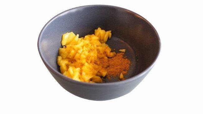 Die geschnittene Mango, das Currypulver und den Süßstoff in eine Schüssel geben. Die geschnittene Mango, das Currypulver und den Süßstoff in eine Schüssel geben.