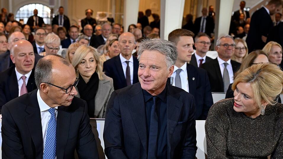 Zum ersten Mal gemeinsam beim Einheitsfest: Bundestagspräsidentin Julia Klöckner (CDU) mit ihrem Lebensgefährten Jörg Pilawa (M.) - im Gespräch mit Bundeskanzler Friedrich Merz (CDU) in der Ludwigskirche.