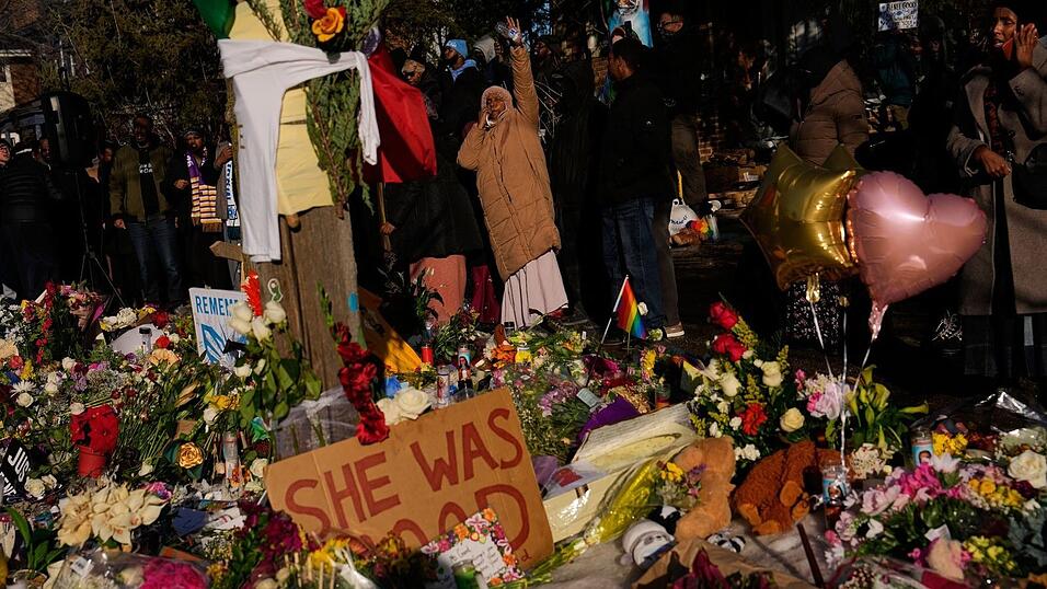 Menschen versammeln sich um eine provisorische Gedenkst&auml;tte zu Ehren der Frau, die von einem ICE-Beamten t&ouml;dlich erschossen wurde.