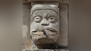 Absicht oder passend? Das Gesicht des Wasserspeiers verdreht die Augen, weil ihm die Lippen abgesprengt wurden. Absicht oder passend? Das Gesicht des Wasserspeiers verdreht die Augen, weil ihm die Lippen abgesprengt wurden.