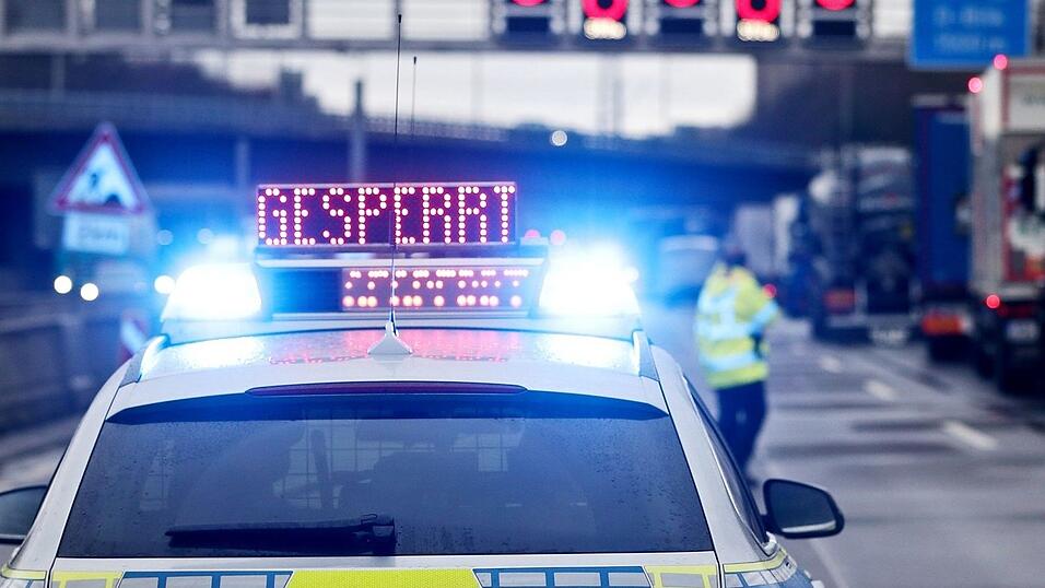 Auf einem Polizeifahrzeug leuchtet die Aufschrift 'Gesperrt'.