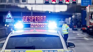 Auf einem Polizeifahrzeug leuchtet die Aufschrift 'Gesperrt'.