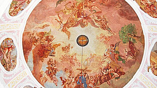 Das Kuppelfresko stammt von 1733, geschaffen von Joseph Anton Merz. Es ist ein Triumphbild, das aufs Sühnewerk Christi Bezug nimmt.