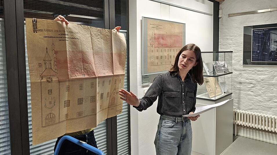 Diplomarchivarin Johanna Girschick (rechts) zeigt den Originalplan zur Umgestaltung der Fassade des Herzogsschlosses von 1910.