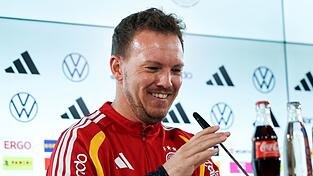 Julian Nagelsmann richtet das Mikrofon bei der Pressekonferenz.