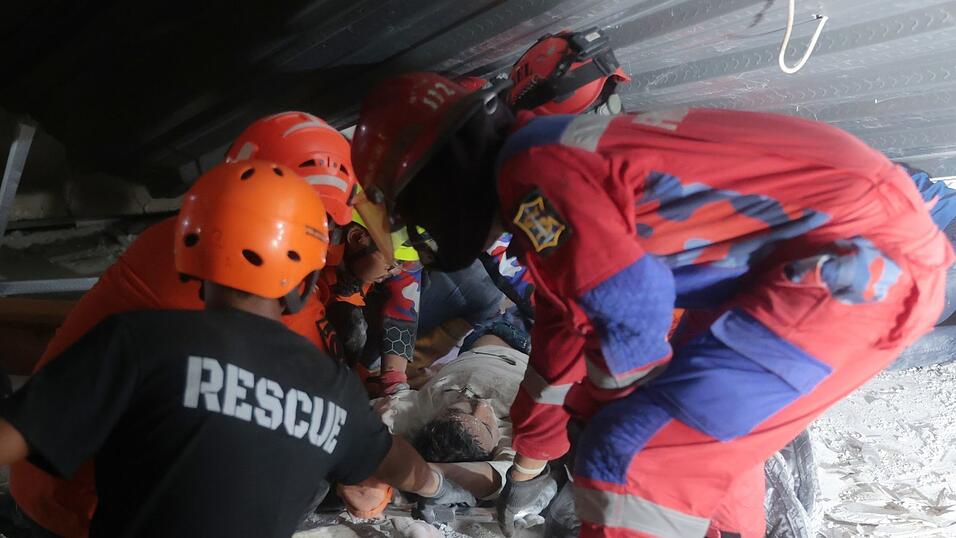 Die Retter suchten fieberhaft unter den Trümmern nach Überlebenden. Die Retter suchten fieberhaft unter den Trümmern nach Überlebenden.