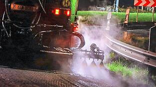 Eine Spritzmaschine bringt nachts Bitumen auf die Fahrbahn auf. Der Stra&szlig;enbau reagiert empfindlich auf Entwicklungen am Roh&ouml;lmarkt - denn Bitumen und Asphaltkleber basieren auf Erd&ouml;l.