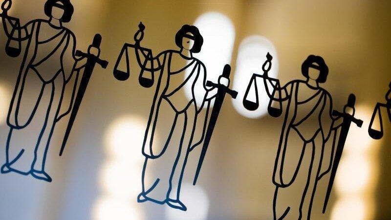 Die Justitia ist an einer Scheibe am Eingang zum Oberlandesgericht zu sehen.