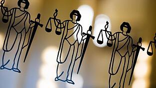 Die Justitia ist an einer Scheibe am Eingang zum Oberlandesgericht zu sehen.