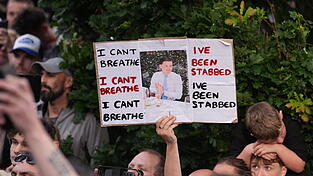 Demonstranten stehen vor einer Polizeiwache in Southampton. Viele halten Schilder mit Nowaks Foto und seinen letzten Worten hoch.