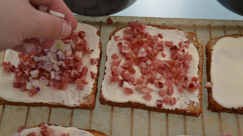 Zwiebeln über den Schinken geben.
