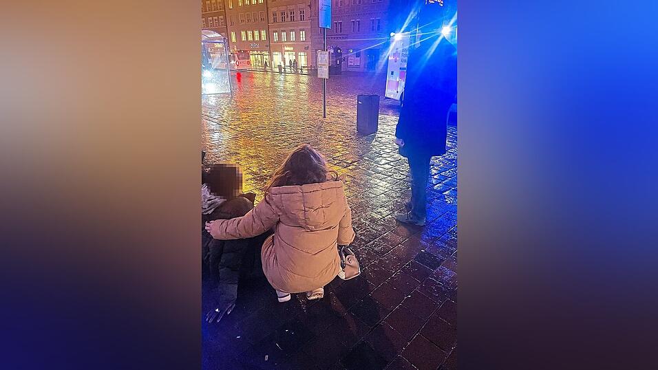 Eine Helferin st&uuml;tzt das Opfer des Schl&auml;gers und wartet mit ihm auf den Rettungsdienst, der gerade eintrifft.