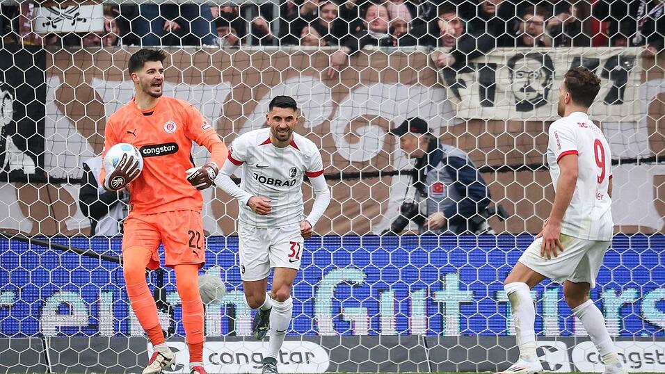St. Paulis Torwart Nikola Vasilj (l) hält einen Elfmeter von Freiburgs Vincenzo Grifo (M).