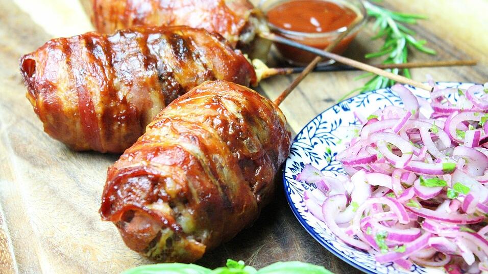 Finger-Food mal anders: Diese Hackfleischspieße sind mit Käse gefüllt und mit Speck ummantelt.