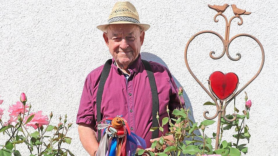 Sepp Danner vor seinem Haus in Oberharthausen. In der Hand h&auml;lt er den Hochzeitsladerstecken, denn bis vor einigen Jahren hat er als Hochzeitslader auch seine Gstanzl auf Hochzeiten gesungen.