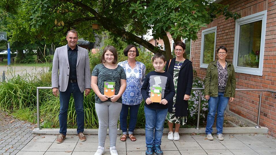 B&uuml;rgermeister Alfred Holzner (l.) und Umweltreferentin Veronika Oberpriller (r.) &uuml;bergaben die 'M&ouml;hrchenhefte' stellvertretend an Schulleiterin Sabine Obermeier (Astrid-Lindgren-Schule, Mitte), Sabine Seemann (Grundschule Rottenburg) und zwei Sch&uuml;ler der Astrid-Lindgren-Schule.