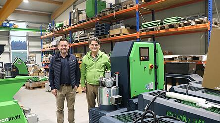 Kurt Fischer (l.) und Reinhold Eder, Gesch&auml;ftsf&uuml;hrer und Gr&uuml;nder von &bdquo;Ecokraft&ldquo;, stehen in Niederwinkling neben einer Pelletieranlage.