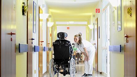 Eine Pflegefachkraft k&uuml;mmert sich um eine Patientin.