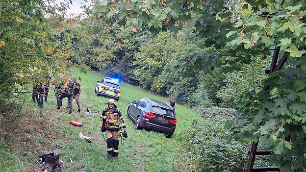 Polizei und Feuerwehr stehen nach einer Verfolgungsjagd neben einem Auto in einem Waldst&uuml;ck. Ein 17-J&auml;hriger hat sich bei&nbsp;Passau&nbsp;in einem gestohlenem Auto eine Verfolgungsjagd mit der Polizei geliefert. Dabei baute er mehrere Unf&auml;lle, wie die Polizei mitteilte.