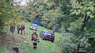 Polizei und Feuerwehr stehen nach einer Verfolgungsjagd neben einem Auto in einem Waldst&uuml;ck. Ein 17-J&auml;hriger hat sich bei&nbsp;Passau&nbsp;in einem gestohlenem Auto eine Verfolgungsjagd mit der Polizei geliefert. Dabei baute er mehrere Unf&auml;lle, wie die Polizei mitteilte.