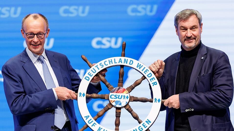 CDU-Chef und Kanzlerkandidat Friedrich Merz (l.) bekommt vom bayerischen Ministerpr&auml;sidenten und CSU-Vorsitzenden Markus S&ouml;der ein wei&szlig;-blaues Schiffs-Steuerrad geschenkt.